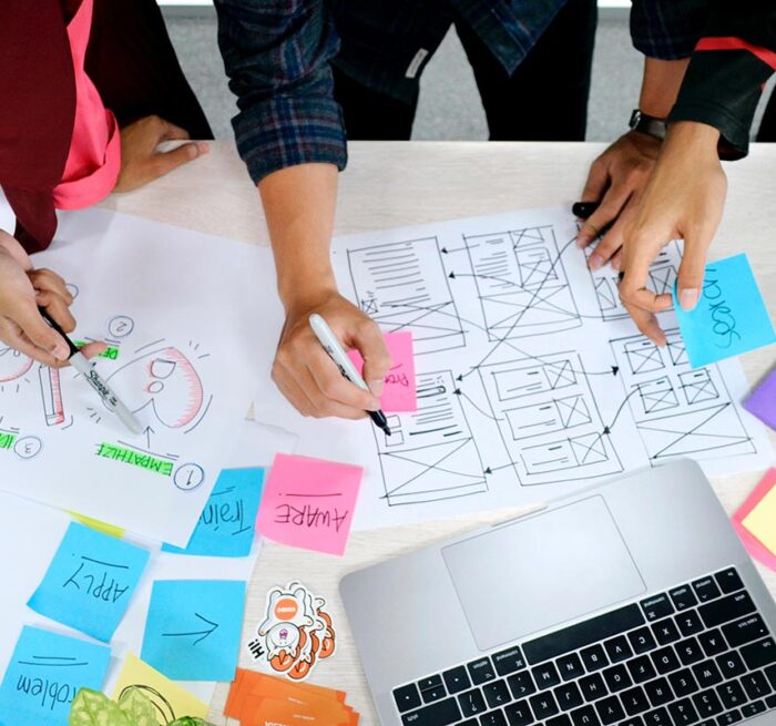 A group of people drawing and writing together on a desk